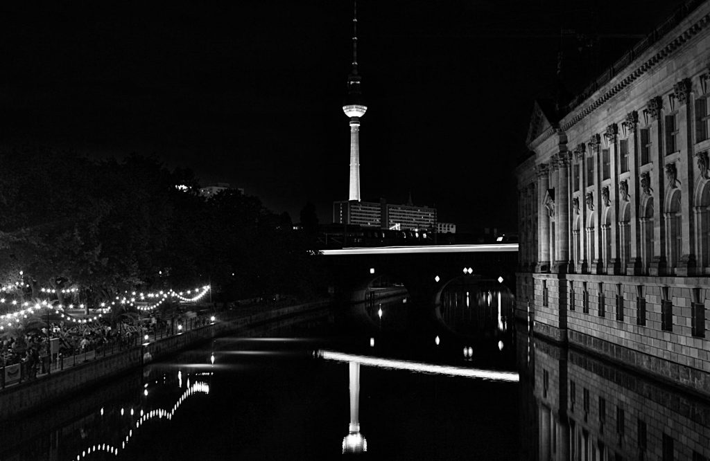 a river with a bridge and a tower in the background